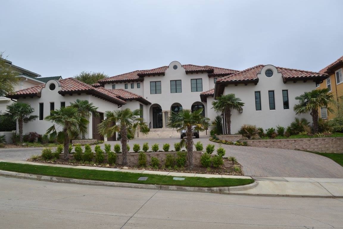 A large white house with a tiled roof and palm trees