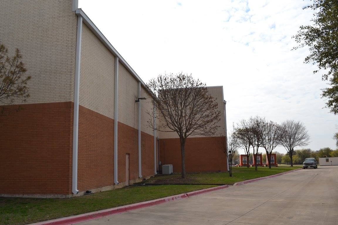 A brick building with a white siding and a red curb