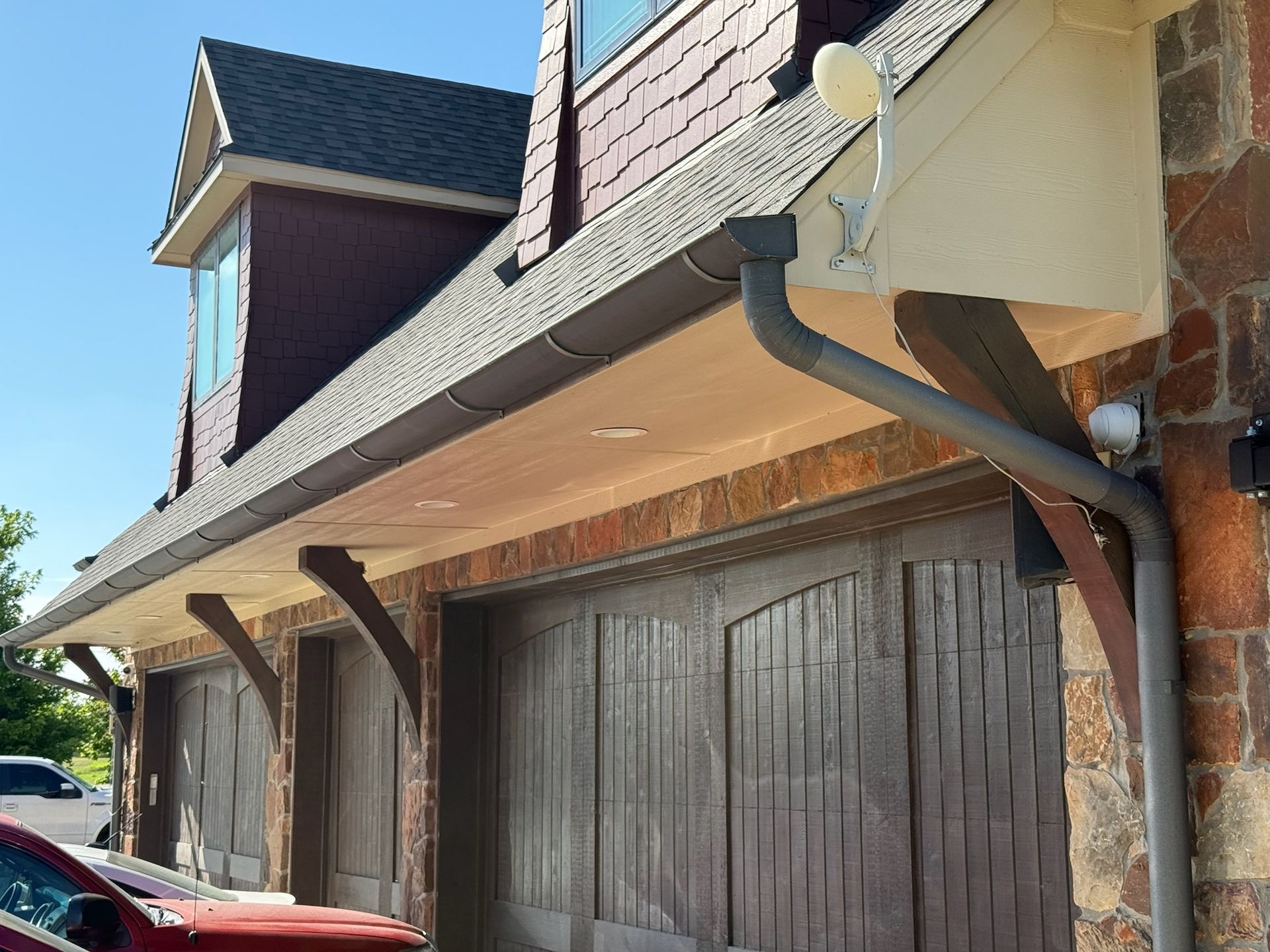 A red car is parked in front of a garage