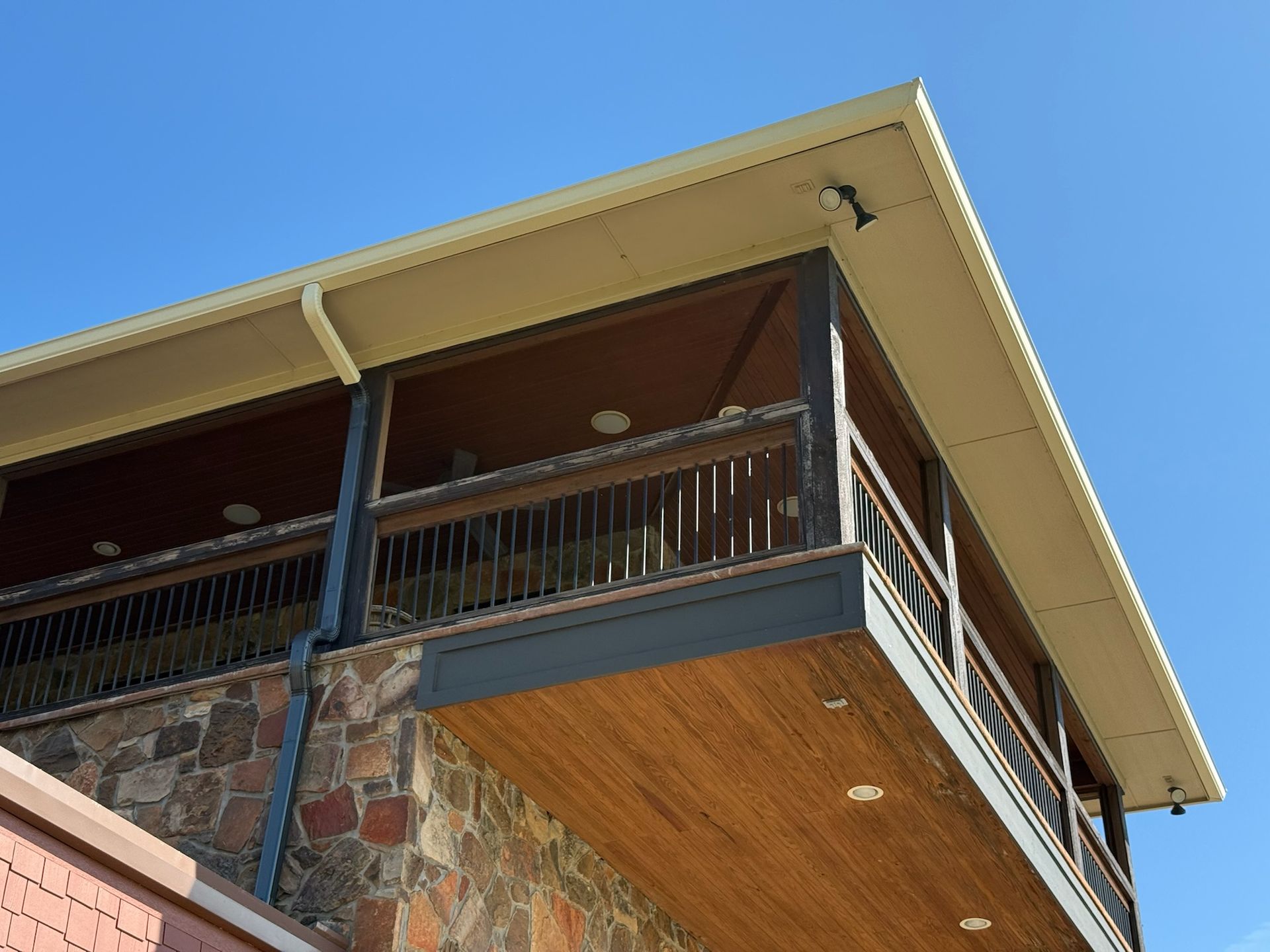 A balcony on the side of a building with a blue sky in the background