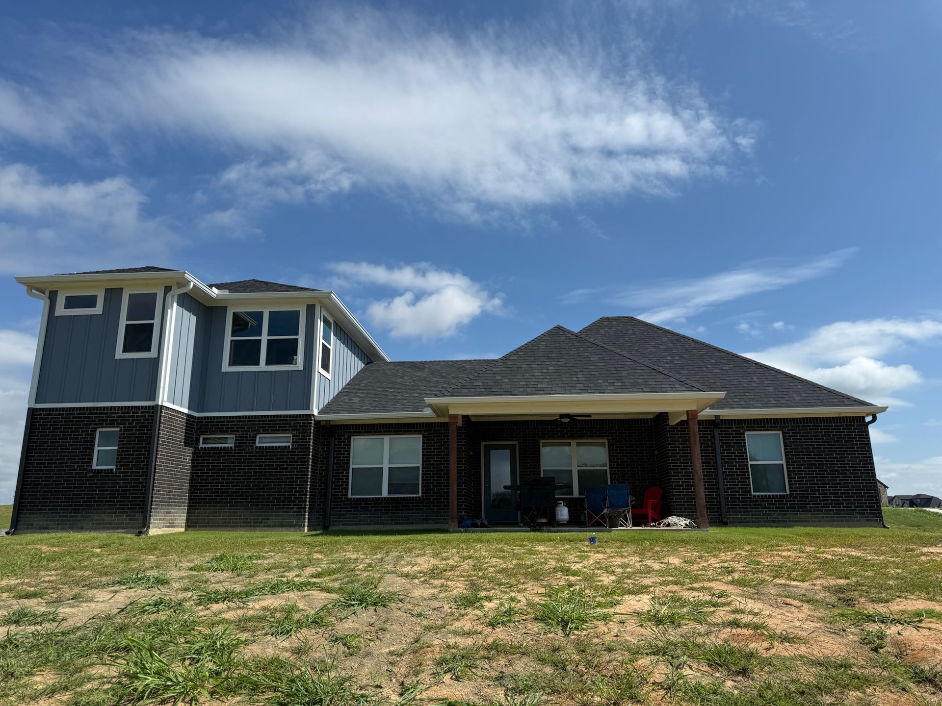 A large house is sitting in the middle of a grassy field.