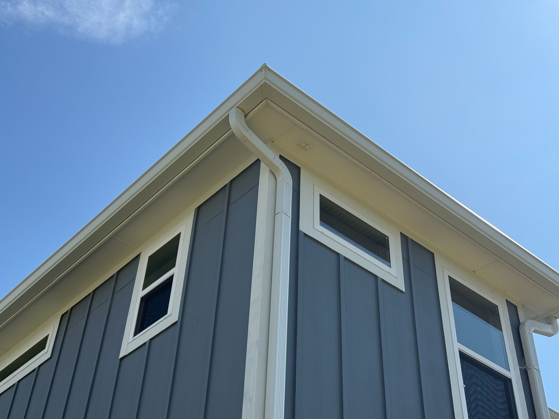 The corner of a house with a blue sky in the background