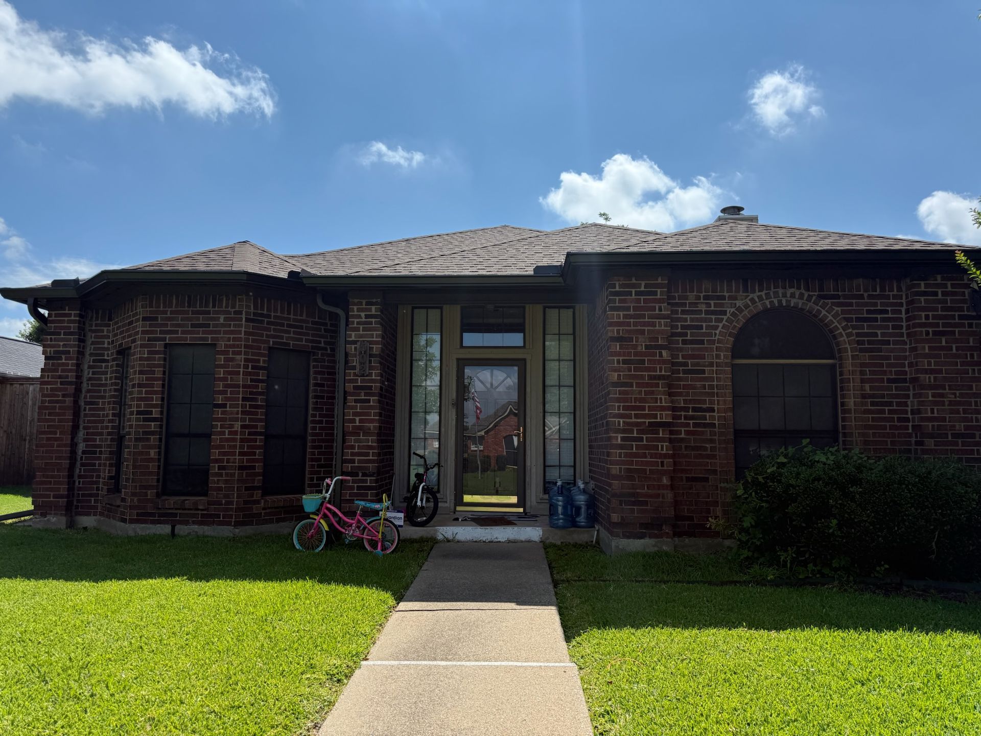 A brick house with a bicycle parked in front of it.