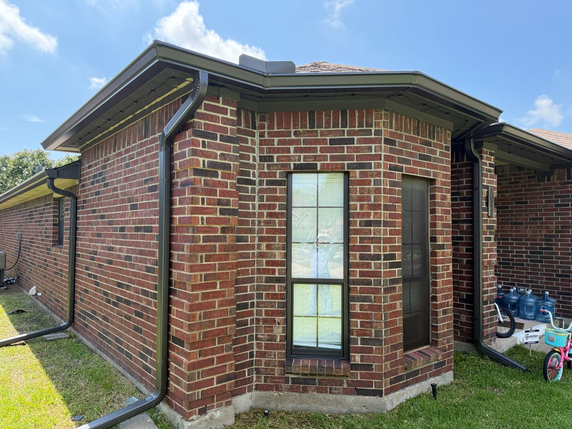 A brick house with a bicycle parked in front of it.