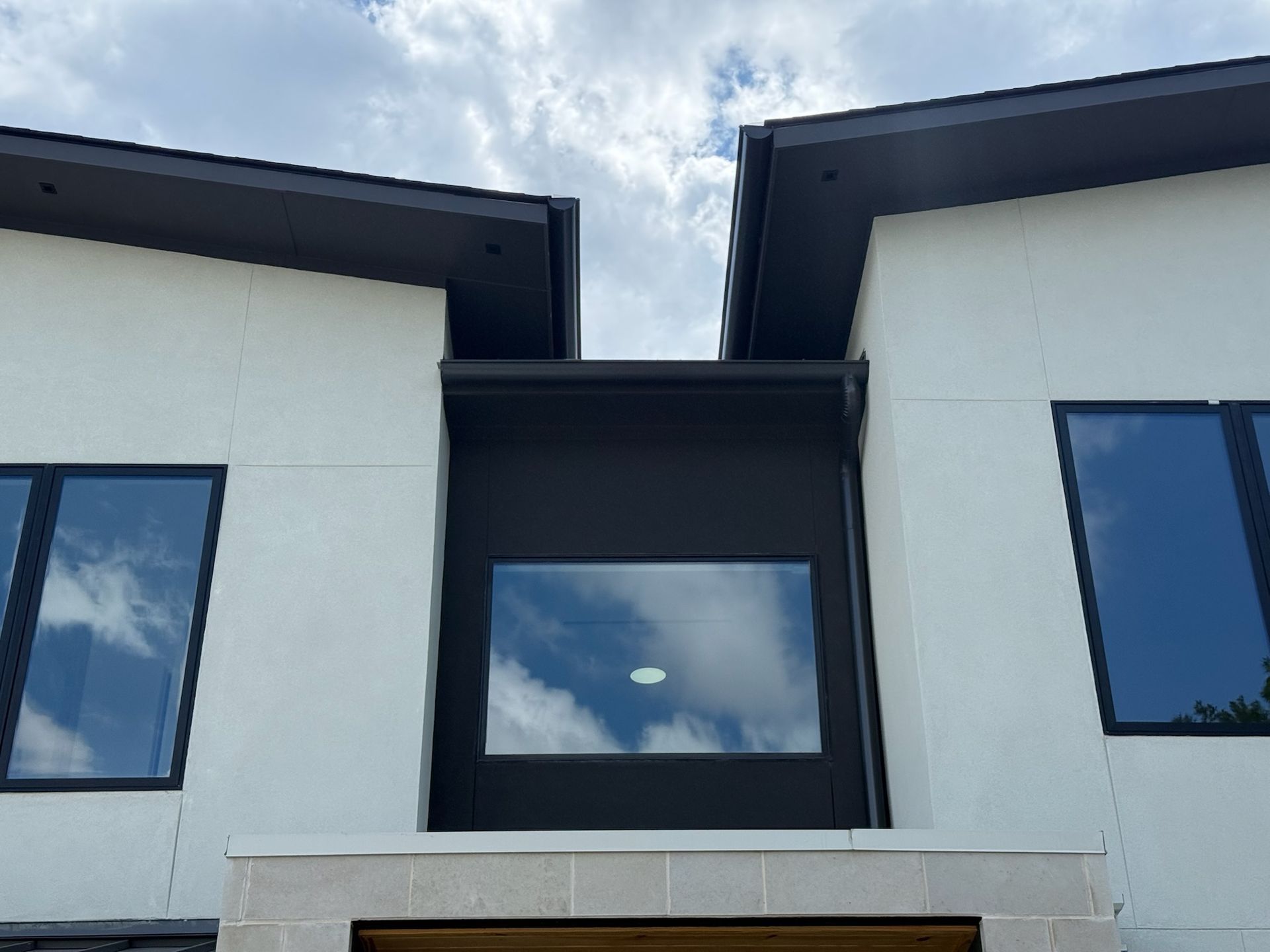 A white house with black windows and a blue sky in the background