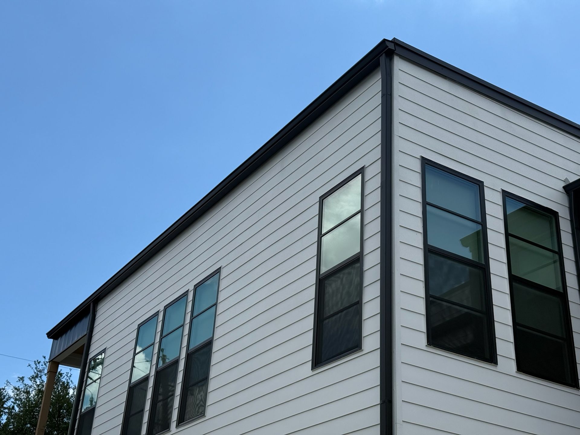A white house with black windows against a blue sky