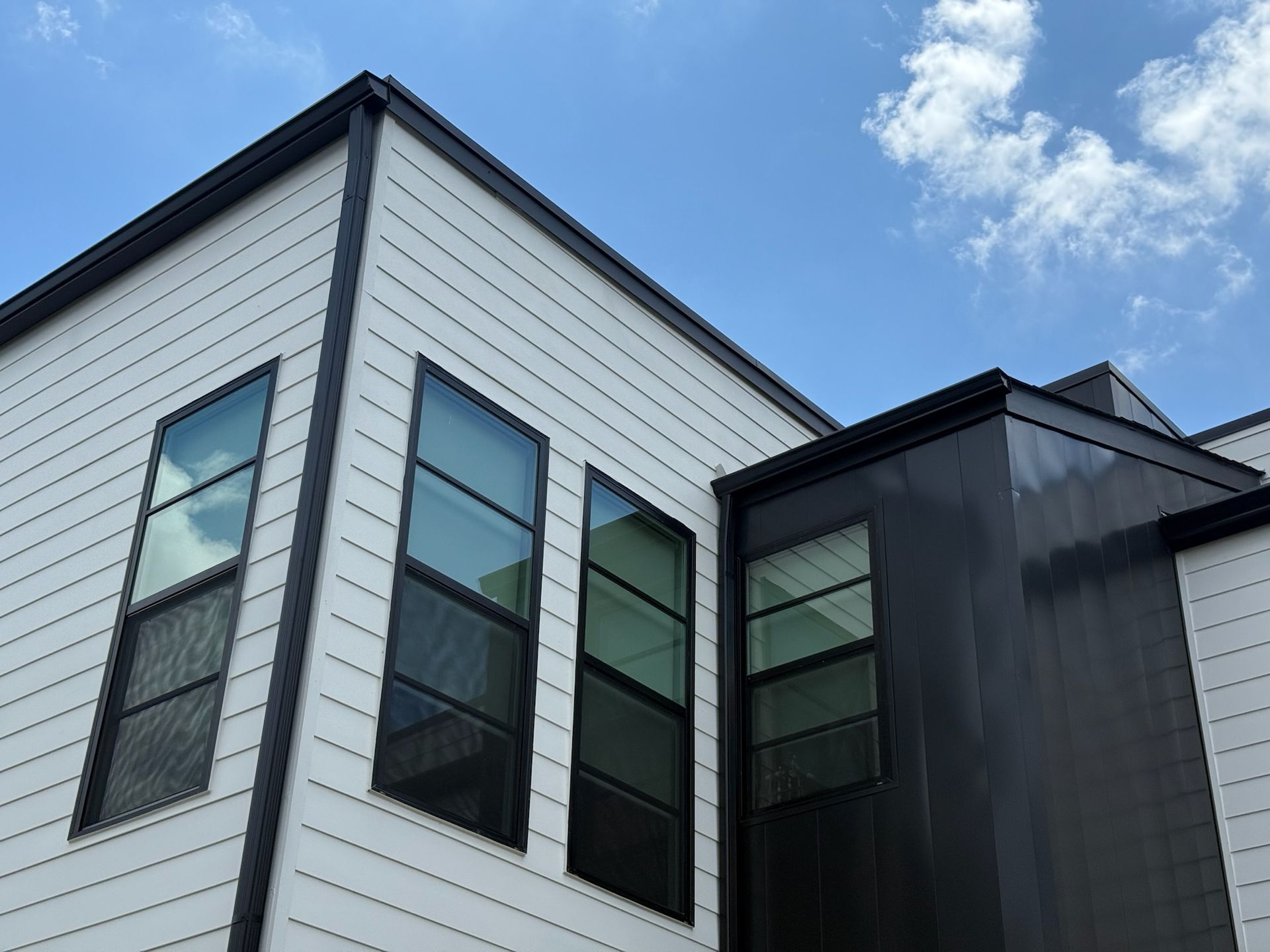 A black and white building with a blue sky in the background.