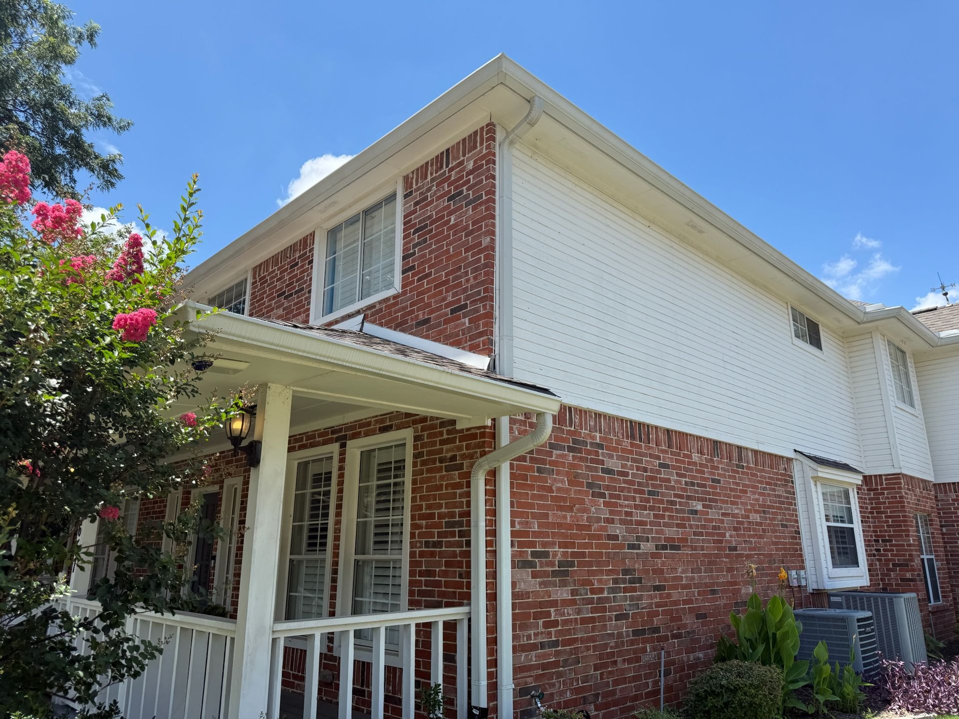 A brick house with a white trim and a porch