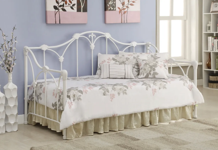 A white day bed in a bedroom with purple walls