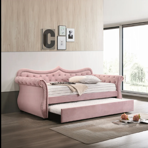 A pink day bed is sitting in a living room next to a window.