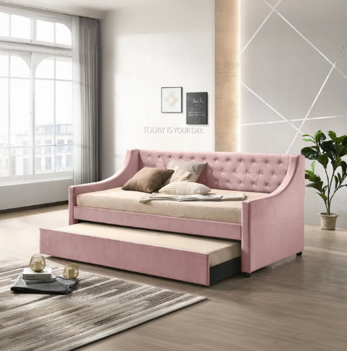 A pink day bed is in a living room next to a window