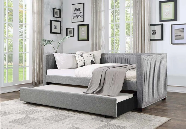 A day bed with a pull out bed underneath it in a bedroom.