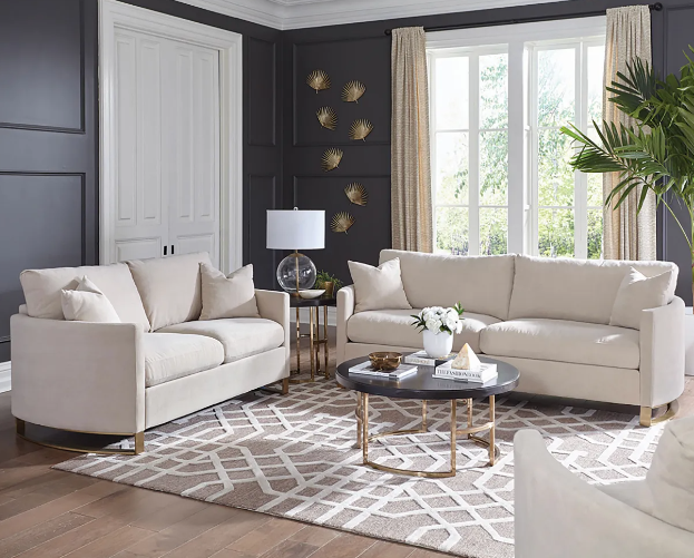 A living room with two white couches and a coffee table.
