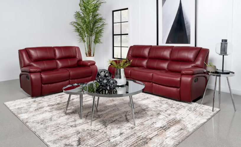 A living room with two red leather couches , a coffee table , and a rug.