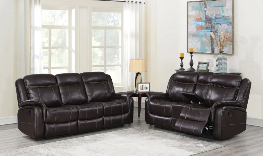 A living room with two brown leather reclining couches and a table.