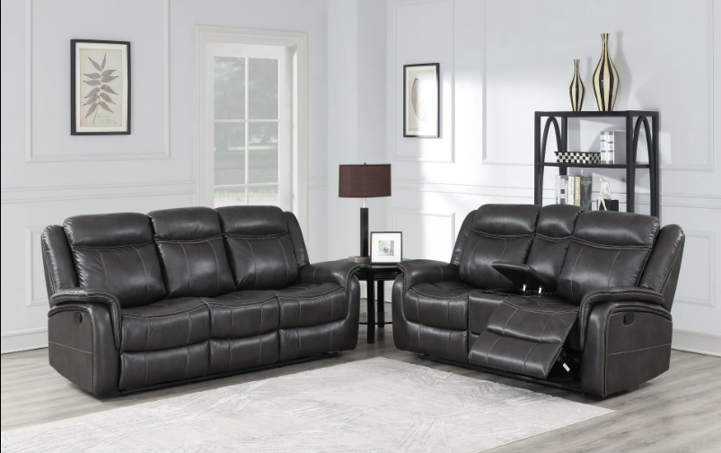 A living room with two black leather reclining couches and a lamp.