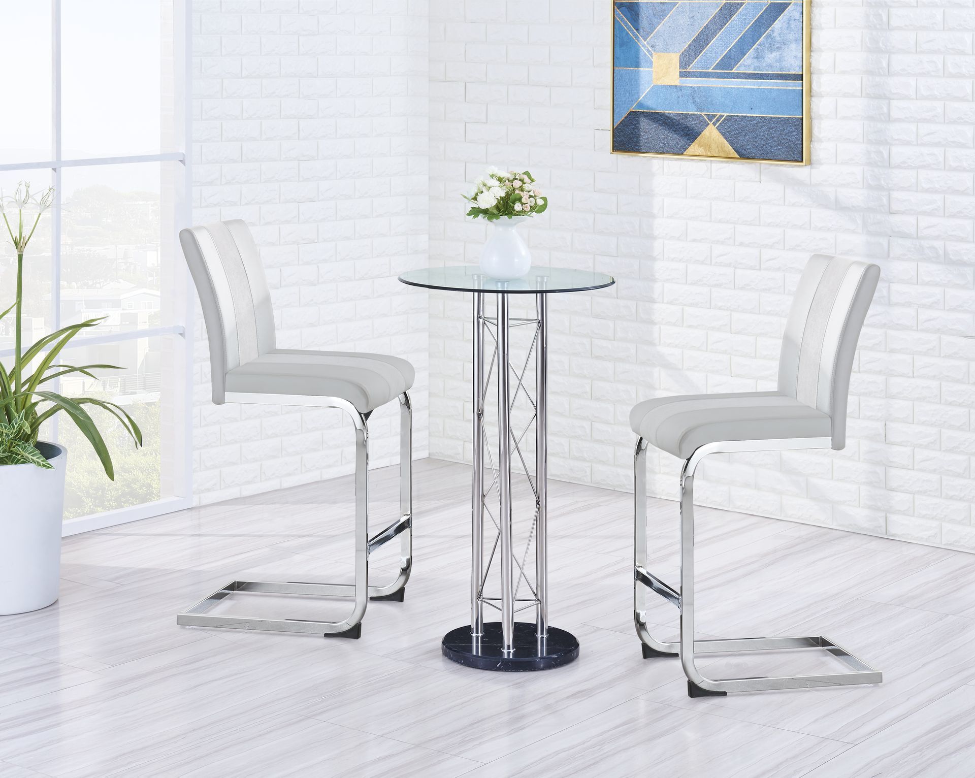 A table and chairs in a room with a painting on the wall.