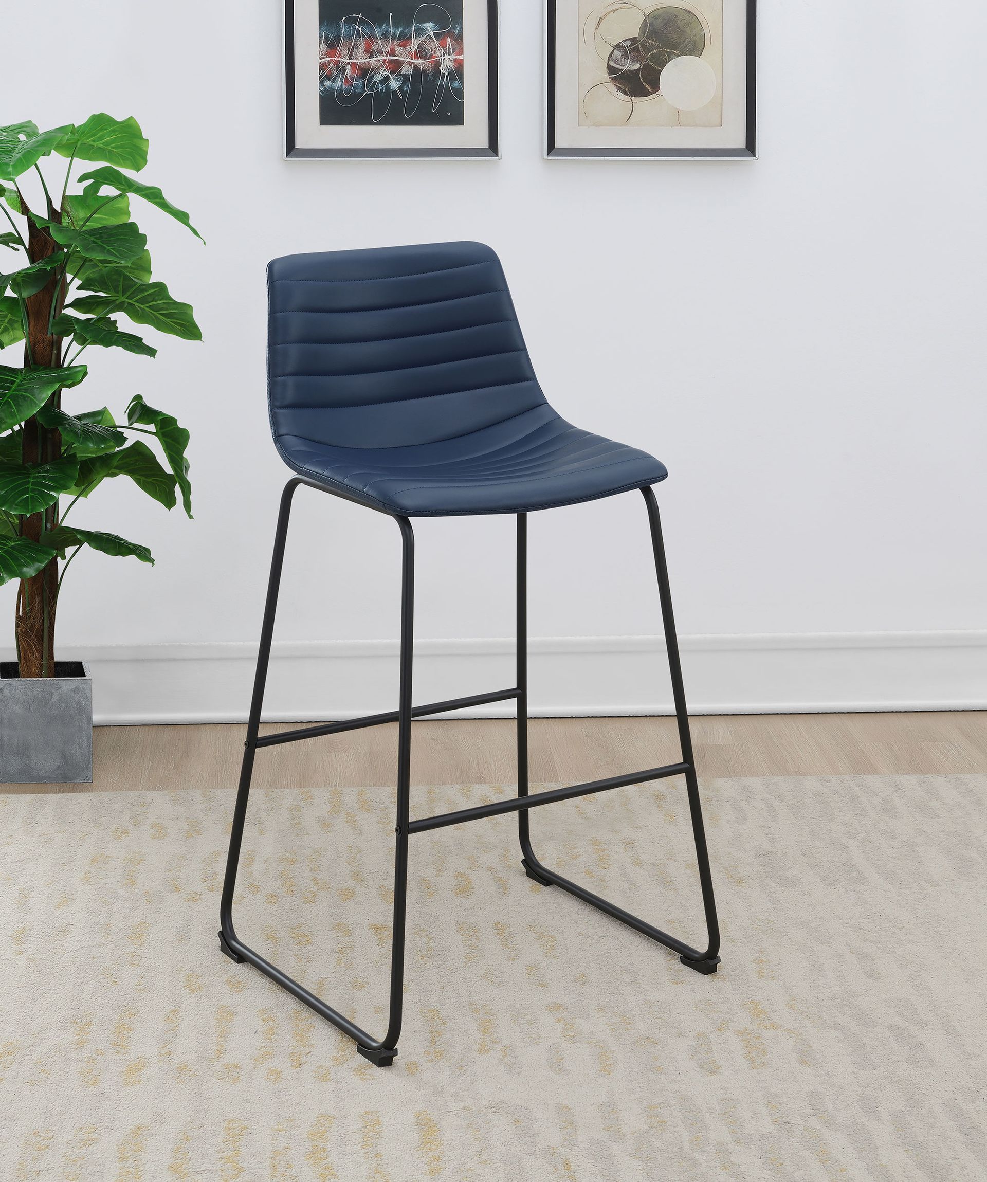 A blue bar stool is sitting on a rug in a living room next to a plant.
