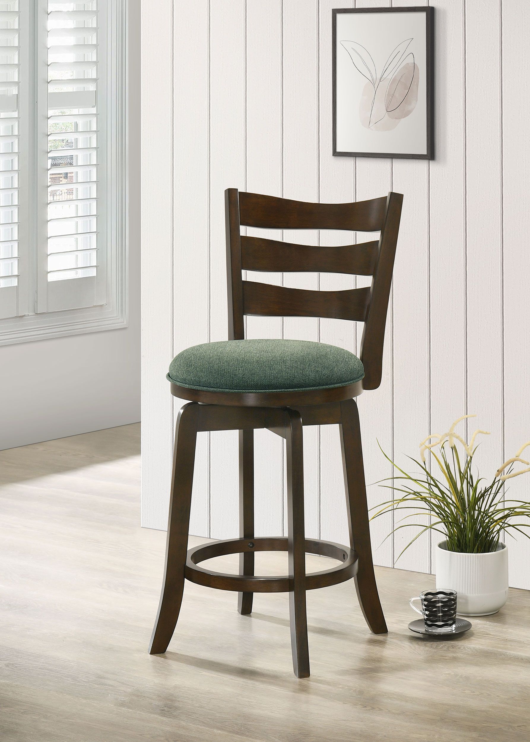 A wooden bar stool with a green cushion is sitting on a wooden floor in a room.
