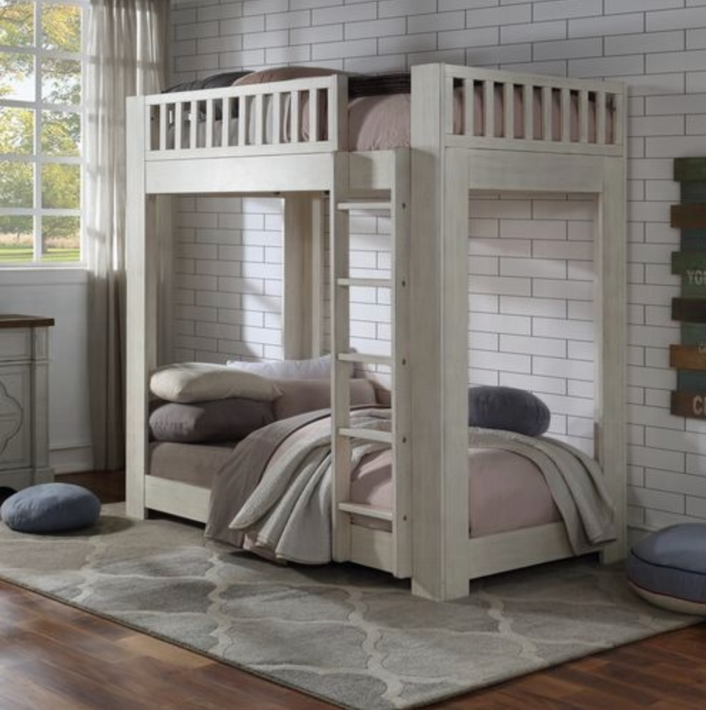 A bunk bed in a room with a brick wall