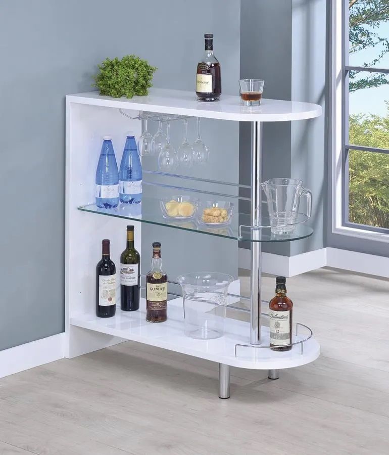 A white bar with wine bottles and glasses on it