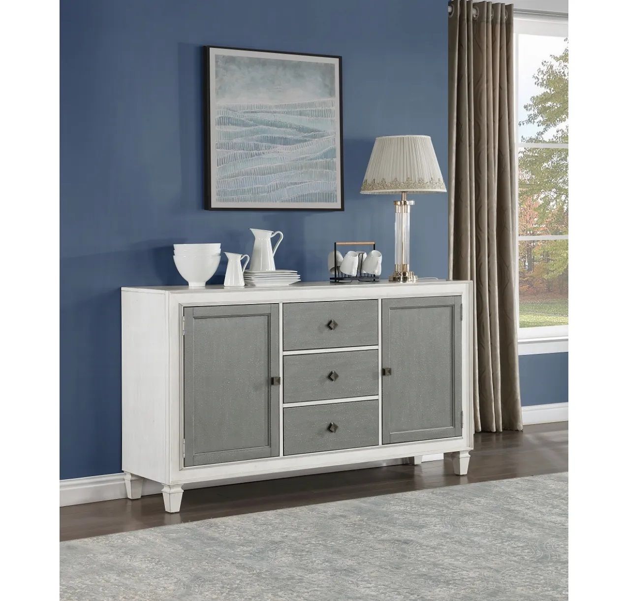 A white dresser with gray doors and drawers is in a living room with blue walls.