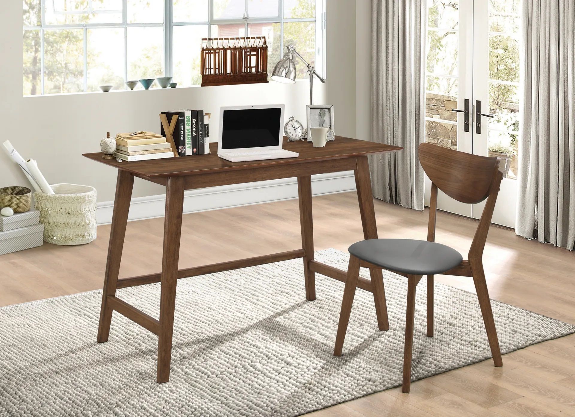 A wooden desk with a laptop on it and a chair in a room.