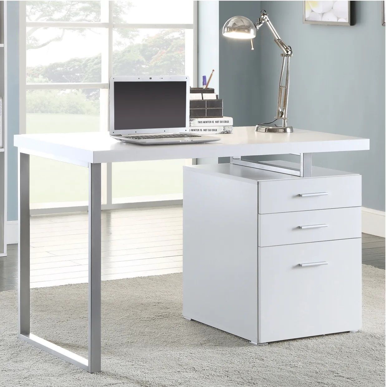 A white desk with a laptop and a lamp on it