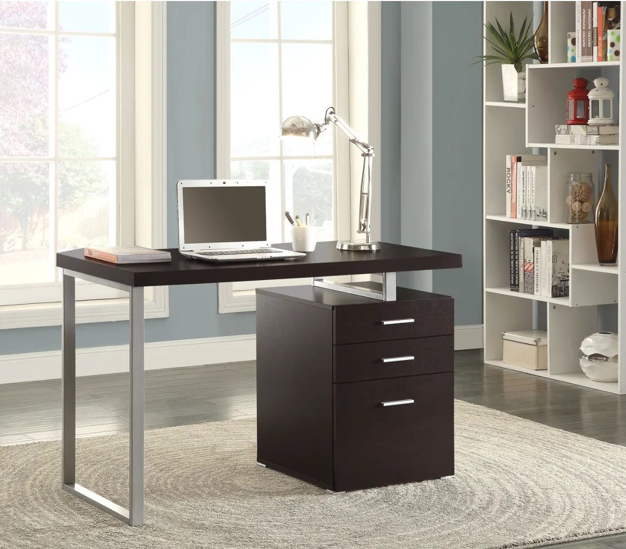 A desk with a laptop on it in a room