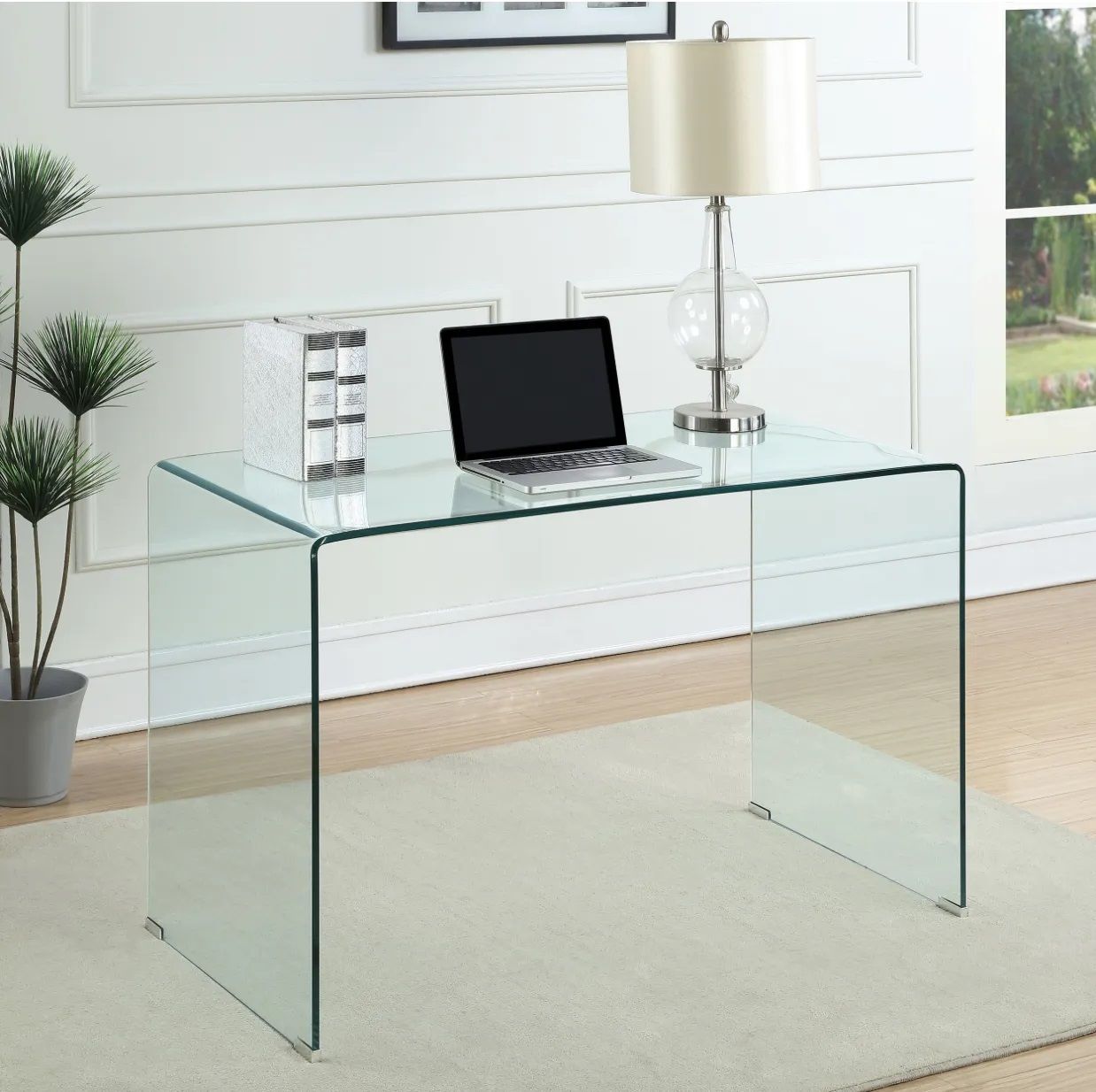 A clear glass desk with a laptop on it