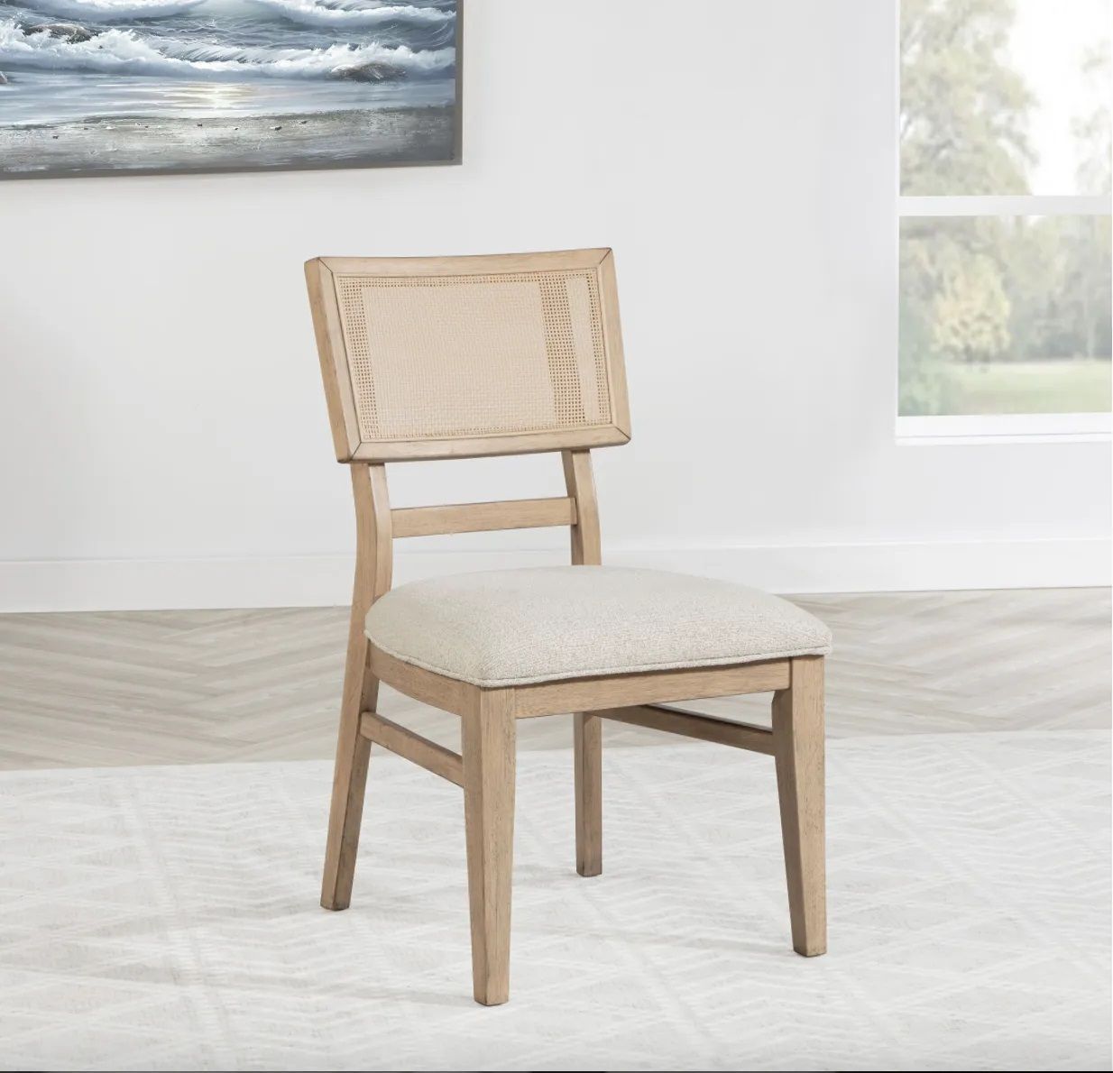 A chair is sitting on a rug in a room with a painting on the wall above it.