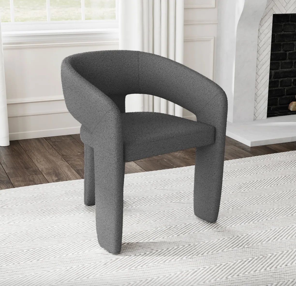 A gray chair is sitting on a white rug in a living room next to a fireplace.