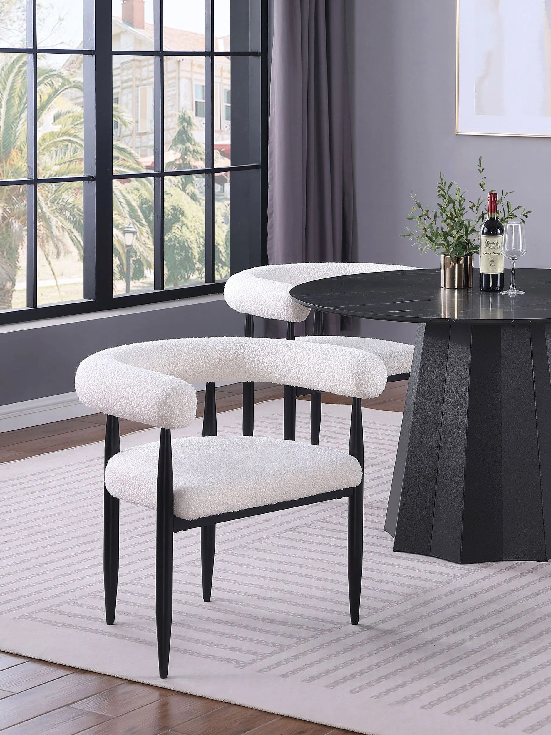 A white chair is sitting next to a black table in a living room.