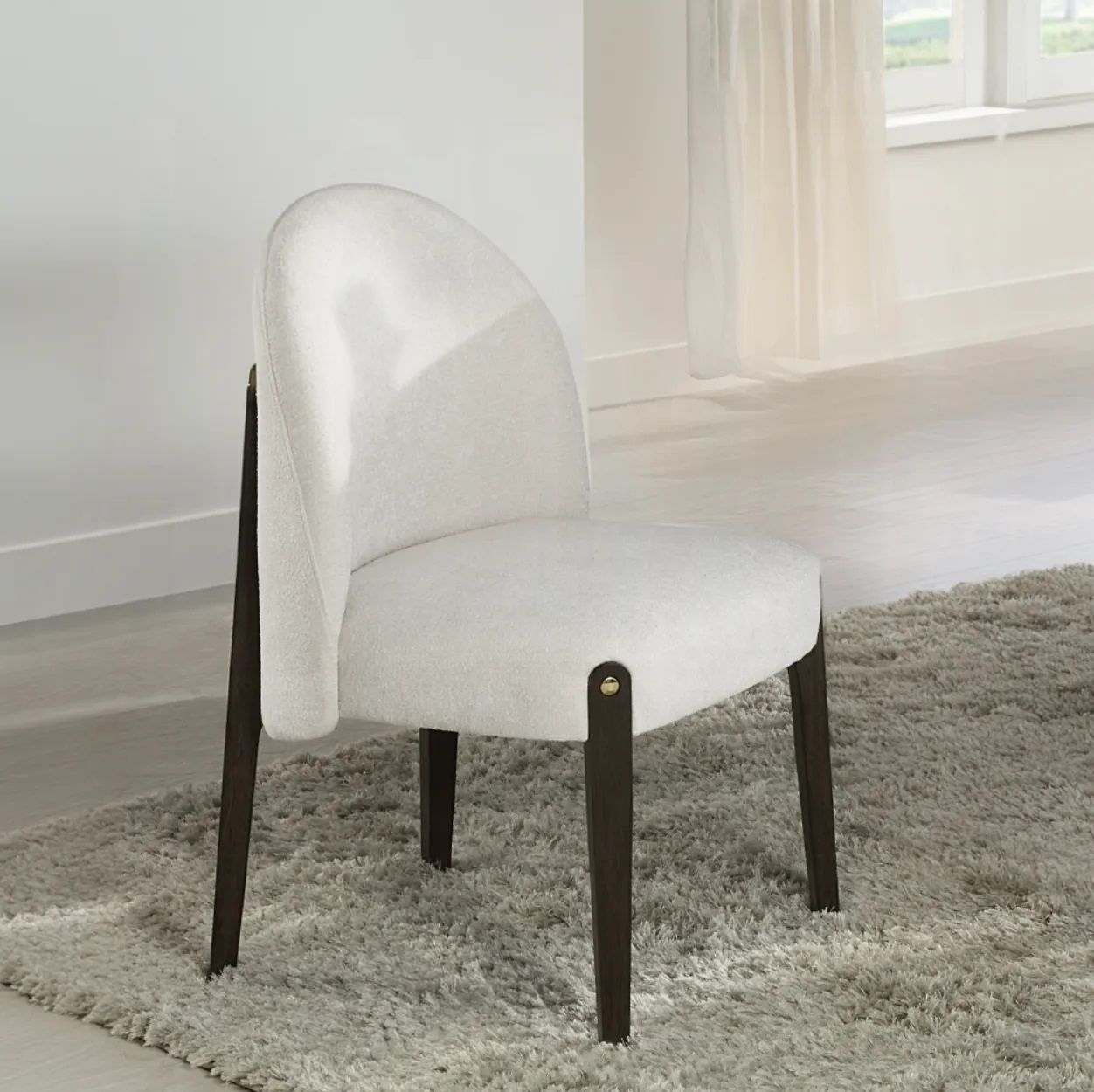A white chair is sitting on a rug in a room
