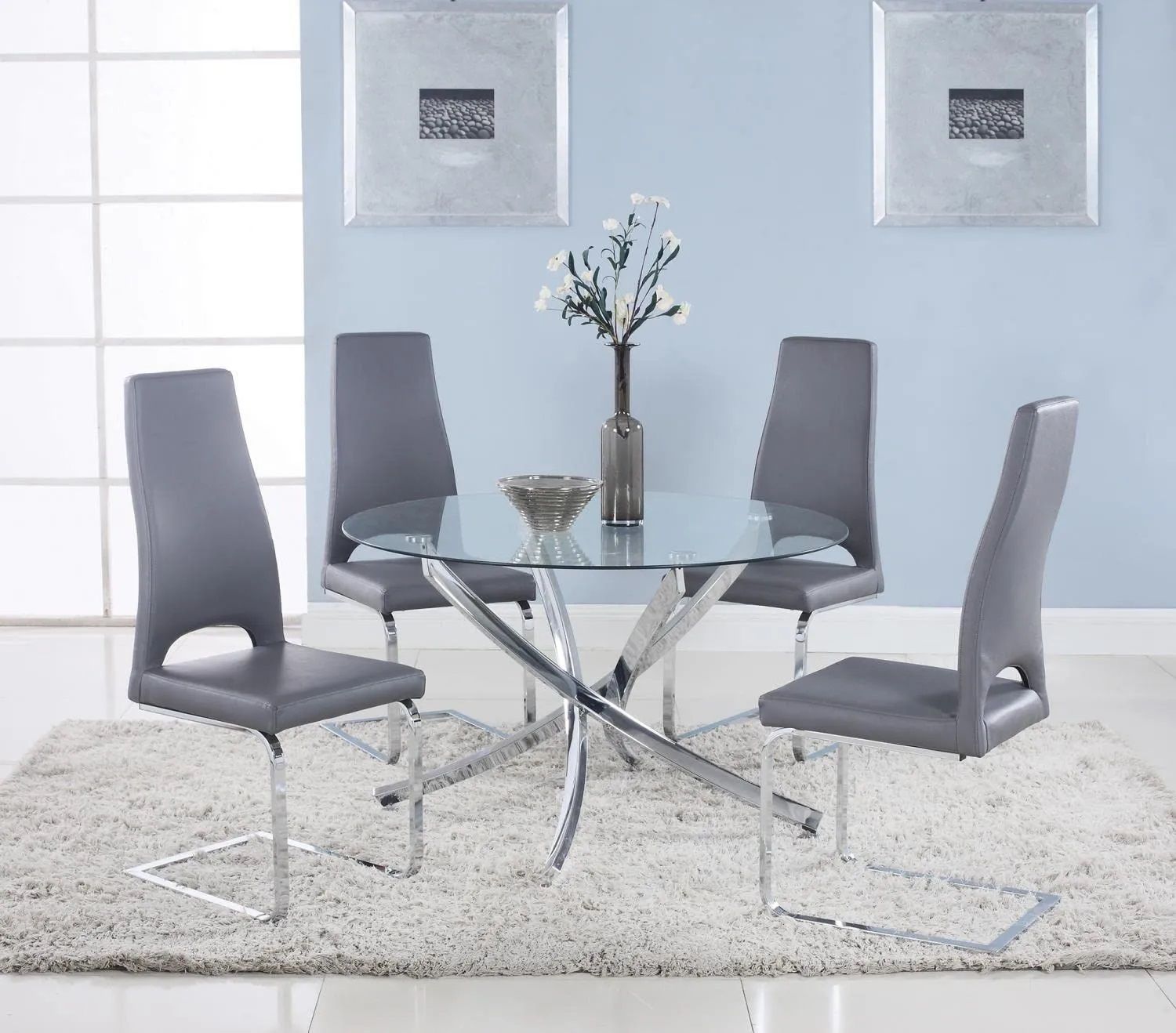 A dining room with a glass table and gray chairs