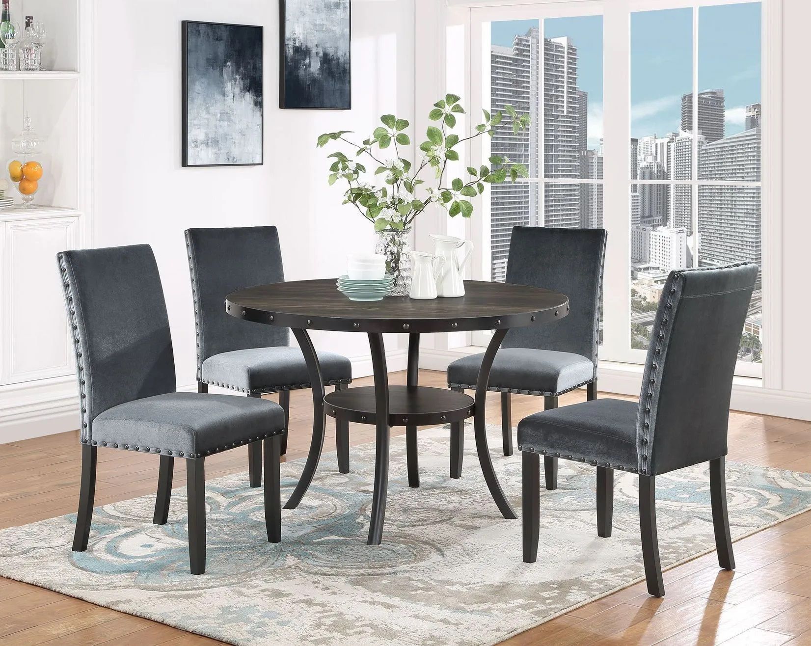 A dining room with a table and chairs and a rug.