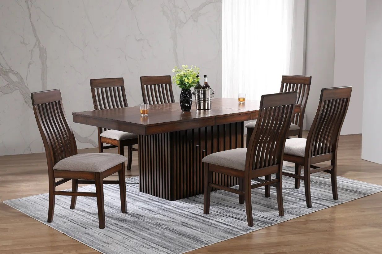 A dining room table and chairs are sitting on a rug.