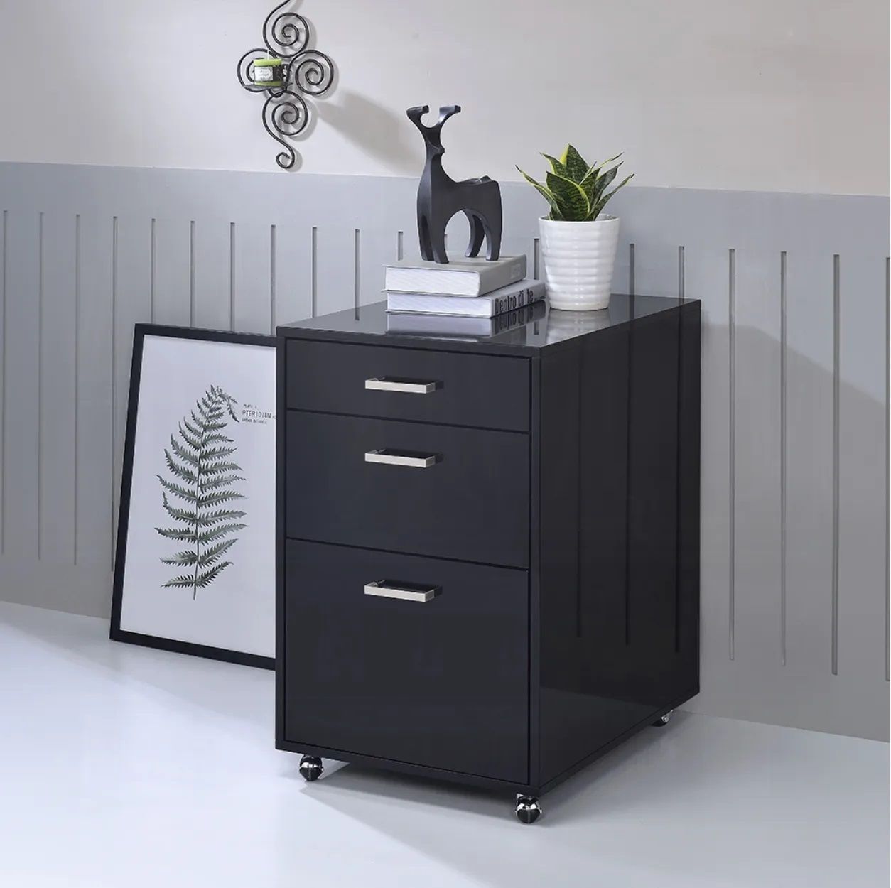 A black filing cabinet with a deer statue on top of it.