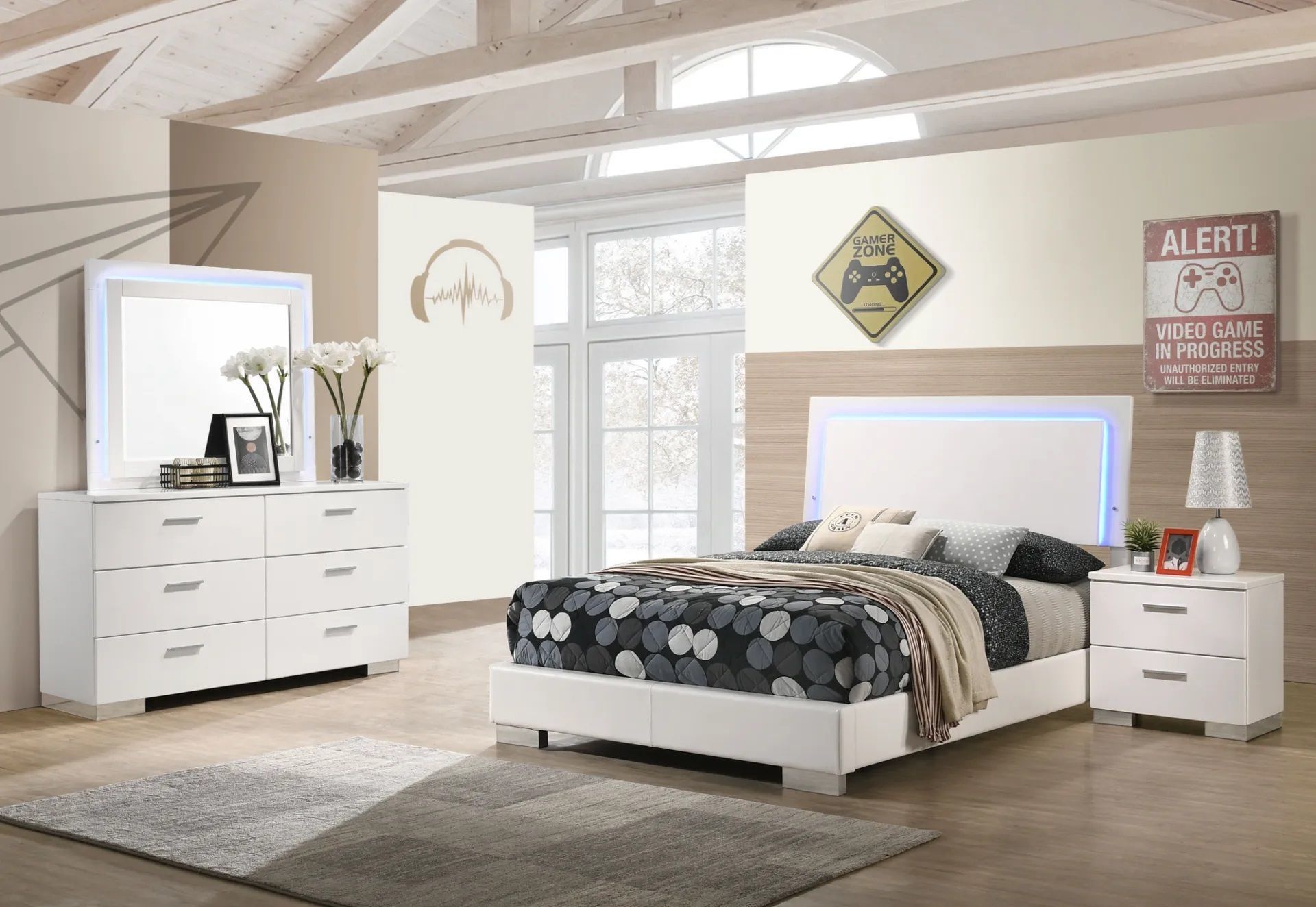 A bedroom with a bed , dresser , nightstand and mirror.