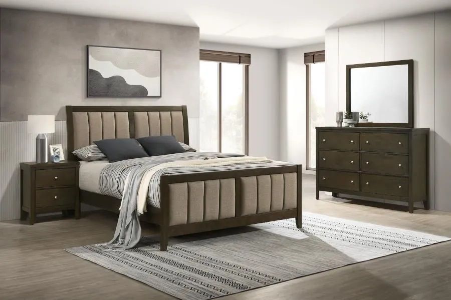 A bedroom with a bed , dresser , nightstand and mirror.