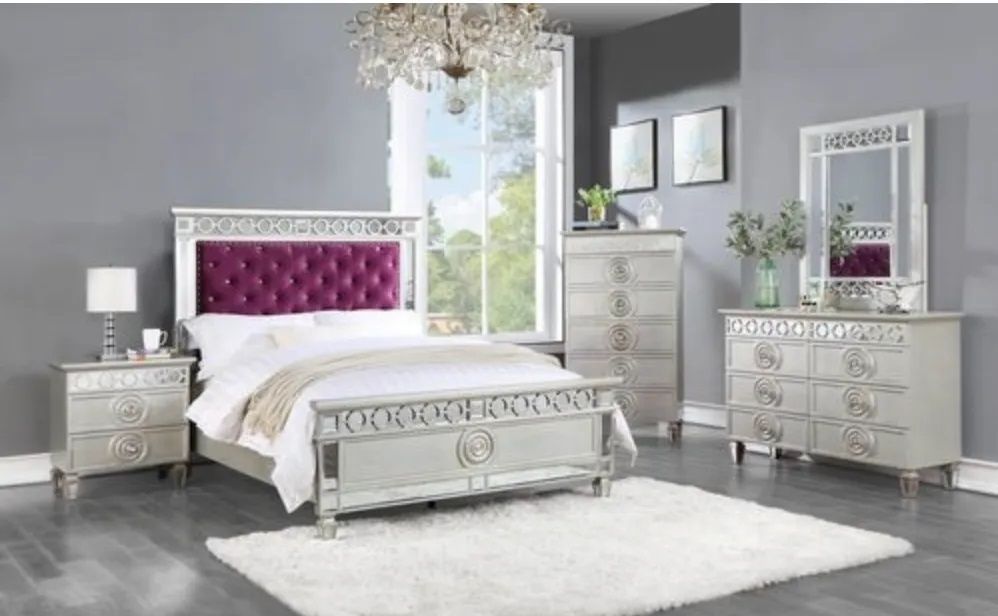 A bedroom with a bed , dresser , nightstand , mirror and rug.