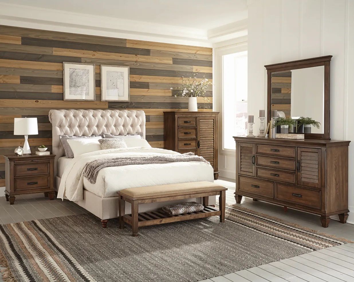 A bedroom with a bed , dresser , mirror and nightstand.