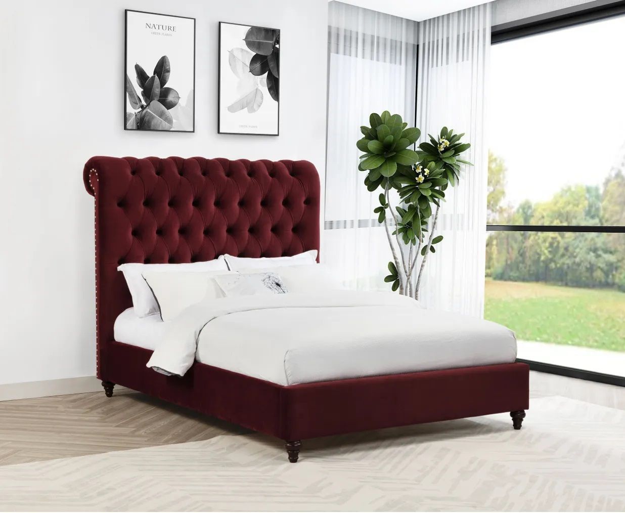 A bed with a red tufted headboard is in a bedroom next to a window.