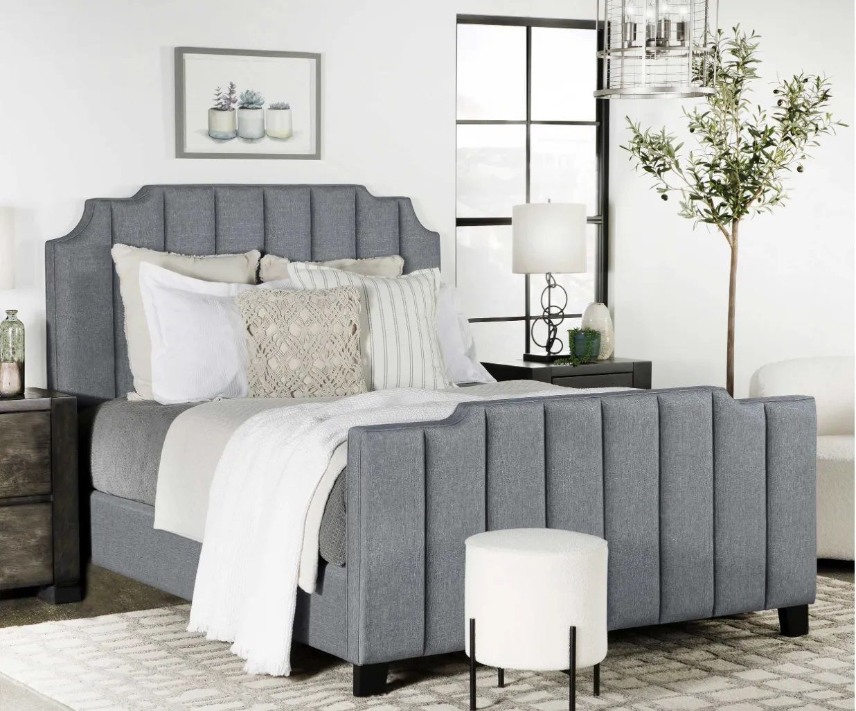 A bedroom with a gray bed and white sheets