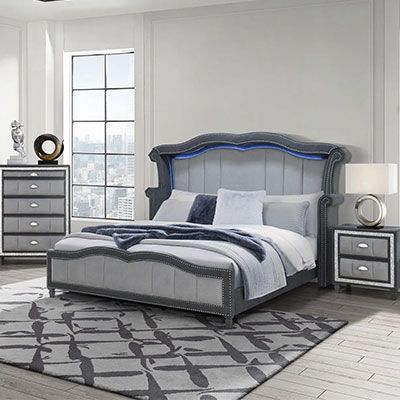 A bedroom with a bed , nightstand , dresser and rug.