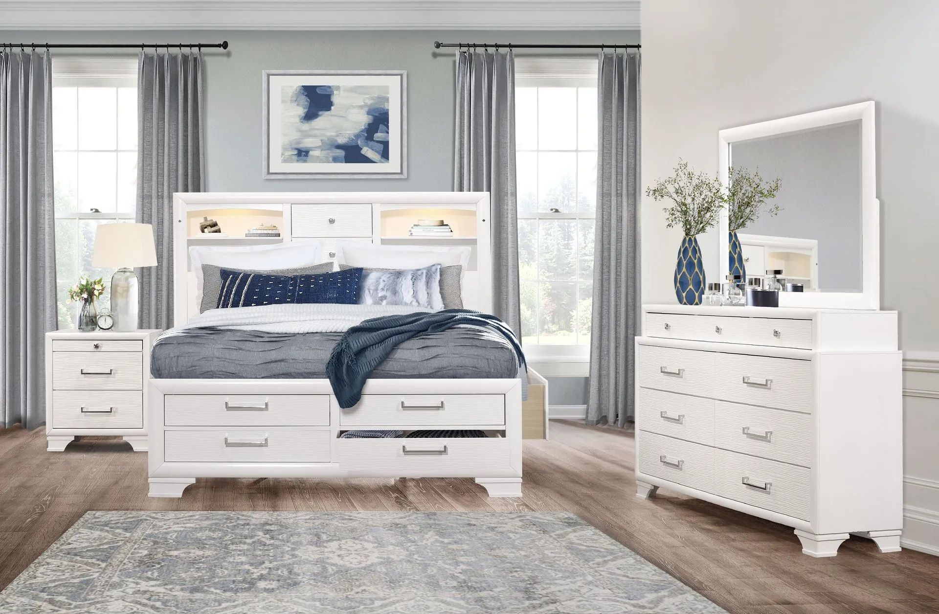 A bedroom with a bed , dresser , mirror and nightstand.