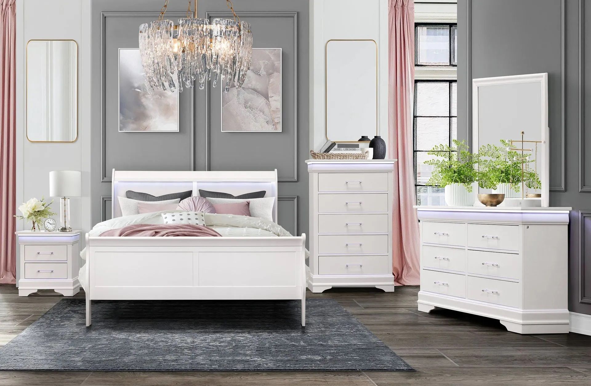 A bedroom with a bed , dresser , nightstand , mirror and chandelier.