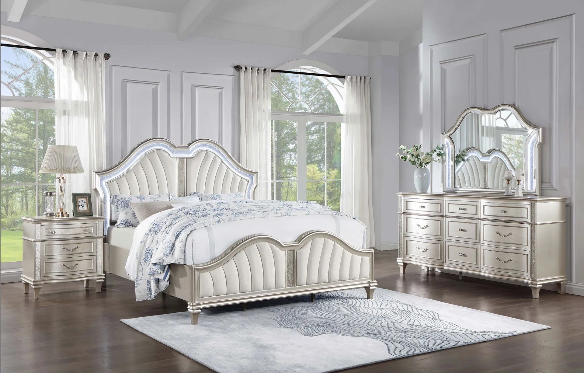 A bedroom with a bed , dresser , nightstand , mirror and rug.