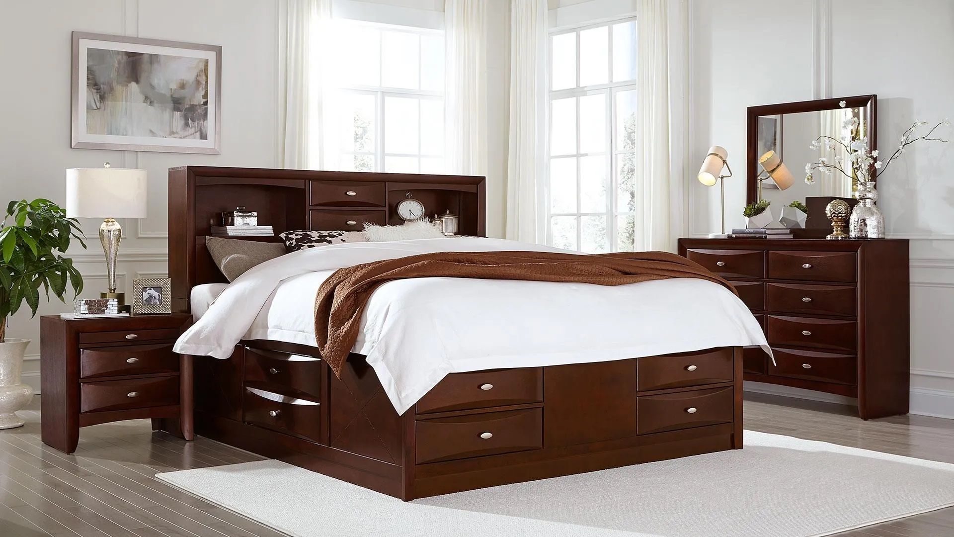 A bedroom with a bed , dresser , nightstand and mirror