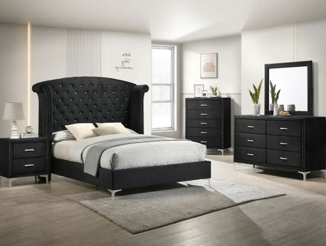 A bedroom with a bed , dresser , nightstand and mirror.